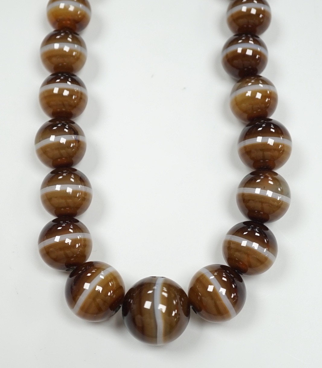 A single strand graduated banded agate circular bead necklace with yellow metal clasp, 46cm.